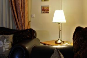 a lamp sitting on a table next to a couch at Helen's Sounio Apartments in Sounio