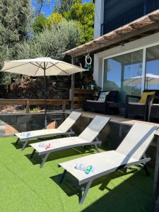 two lounge chairs and an umbrella on a lawn at Casinha in Celorico de Basto