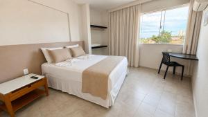 a hotel room with a bed and a desk in it at Atlas Beach Hotel in Fortaleza