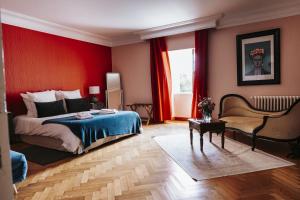 a bedroom with a bed and a red wall at Le clos de Bellevue in Mortagne-sur-Gironde