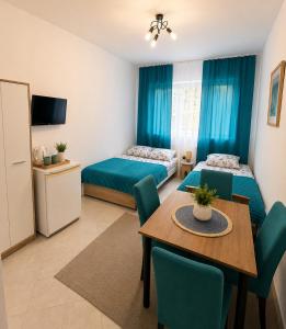 a room with two beds and a table and chairs at Pomarańczowy Domek in Junoszyno