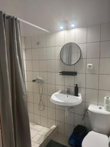 a bathroom with a sink and a mirror and a toilet at Pomarańczowy Domek in Junoszyno +16 photos