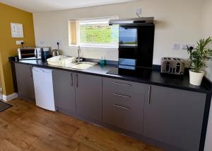 a kitchen with a black counter top and a sink at Minch View Cabin 2, 1 Earlish in Earlish +14 photos