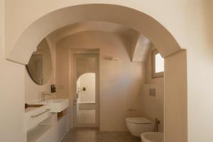 an arched bathroom with a toilet and a sink at Sant'Angelo Ostuni - Il Palazzo in Ostuni