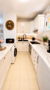 a white kitchen with a sink and a dishwasher at Best Ocean View & Sunset - Los Cristianos in Los Cristianos