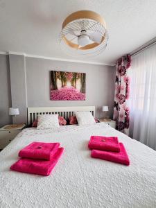 a bedroom with a large bed with pink pillows on it at Best Ocean View & Sunset - Los Cristianos in Los Cristianos
