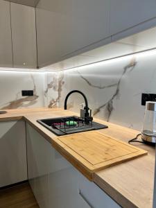a kitchen with a stove and a counter top at Apartament w Kębłowie in Kębłowo