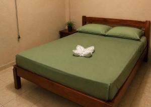 a bed with a white flower on top of it at Amazon City House Iquitos in Iquitos