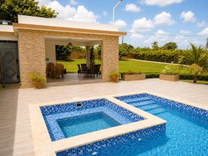 a swimming pool in a backyard with a house at Villa la Santa, piscina infinita - Jacuzzi in Higuey