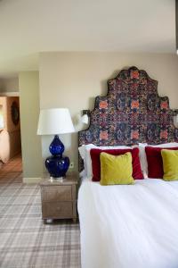 a bedroom with a large bed with a large headboard at The Harcourt Arms in Witney