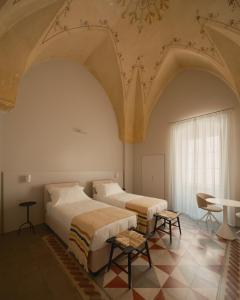 two beds in a room with a ceiling at Sant'Angelo Ostuni - Il Palazzo in Ostuni