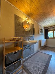 a bathroom with a sink and a wooden ceiling at Haus Asslaber in Hochfilzen