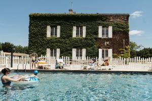 a group of people in a pool in front of a building at Le clos de Bellevue in Mortagne-sur-Gironde