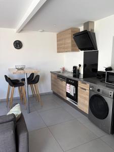 a kitchen with a stove and a table with chairs at appartement avec 2 suites parentales in Angoulême +2 photos