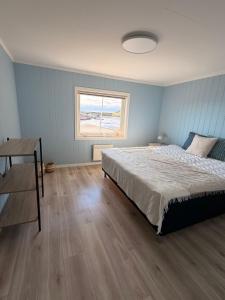 a bedroom with a bed and a desk and a window at Reine Viewpoint House in Reine