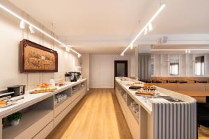 a large room with a buffet line with food at Hotel Fiorio in Flores da Cunha