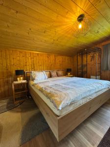 a bedroom with a large bed with a wooden ceiling at Haus Asslaber in Hochfilzen
