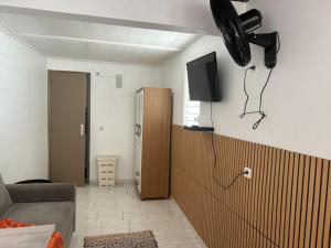 a living room with a couch and a tv on the wall at Studio Relais Les Abymes in Les Abymes