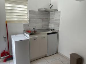 a small kitchen with a sink and a counter at Studio Relais Les Abymes in Les Abymes