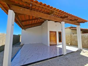 a view of a house with a wooden pergola at Conforto e Tranquilidade, Casa Completa in Martins
