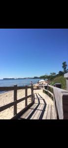 a wooden boardwalk on a beach with the ocean at Havsnära fritidshus in Åhus