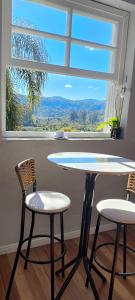 a table and two chairs in front of a window at Casa Finger próx do Centro e do Núcleo de Casas Enxaimel ambiente familiar in Ivoti