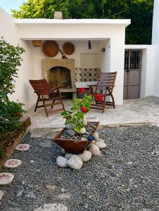 a patio with a fireplace and a table and chairs at Avli in Samothraki
