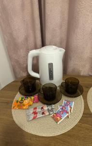 a table with a tea pot and two cups on it at Pomarańczowy Domek in Junoszyno