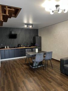 a kitchen and dining room with a table and chairs at Foresthillсоttage in Tyshovnitsa