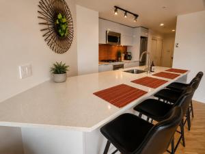 a kitchen with a white counter top and black chairs at Historic Downtown Escape in Vancouver +17 photos