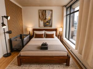 a bedroom with a large bed with a window at Historic Downtown Escape in Vancouver