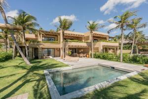 an exterior view of a house with a swimming pool and palm trees at Aqua de Mar Condo Hotel in Icaraí