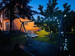 a swing in a yard at night with lights at Pomarańczowy Domek in Junoszyno
