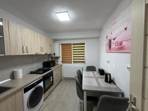 eine kleine Küche mit einem Tisch und einem Herd Oberer Backofen in der Unterkunft Argeş Central in Curtea de Argeş