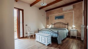 a bedroom with a bed and a wooden floor at Casa Vacanze LA CIMINEA in Erula