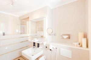 a white bathroom with a sink and a mirror at Appartement mit Dachterrasse und Schloßblick in Heidelberg