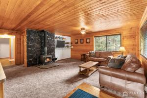 a living room with a couch and a fireplace at Lovely Log Cabin With Fire Pit! in Duck Creek Village