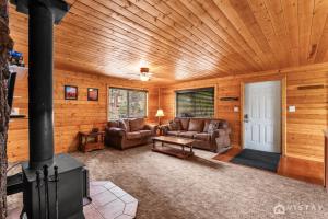 a living room with two couches and a fireplace at Lovely Log Cabin With Fire Pit! in Duck Creek Village