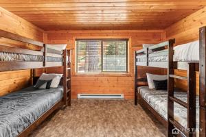two bunk beds in a log cabin with a window at Lovely Log Cabin With Fire Pit! in Duck Creek Village