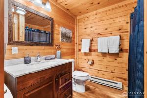 a bathroom with a sink and a toilet in a log cabin at Lovely Log Cabin With Fire Pit! in Duck Creek Village +54 photos