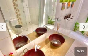 a bathroom with three sinks and a mirror at Vistamar Arco das Flores 2 in Taíba +49 photos