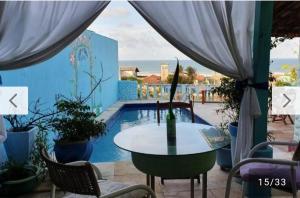 a table and chairs next to a swimming pool at Vistamar Arco das Flores 2 in Taíba
