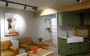 a kitchen with green cabinets and a sink and a table at L Atelier Secret in Guebwiller +11 photos