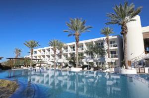 a large swimming pool in front of a hotel with palm trees at Condo Cortes La Paz in La Paz