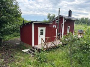 a red house with a ramp leading to it at The Hermits Hut in Österby