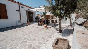 a patio with a table and an umbrella at Casa Vacanze LA CIMINEA in Erula