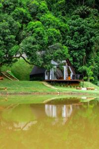 ein kleines Haus neben einem Gewässer in der Unterkunft Chalé Time stop in Cachoeiras de Macacu