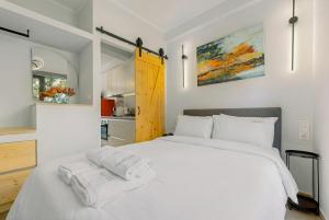 a bedroom with a white bed with towels on it at InTown Suite in Lefkada