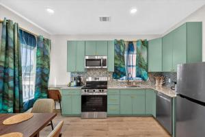 a kitchen with green cabinets and a table at Ninas Villas - Brand New Luxury Villas in Galveston