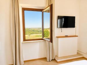 a room with a window and a flat screen tv at Puesta del Sol Roma in Rome